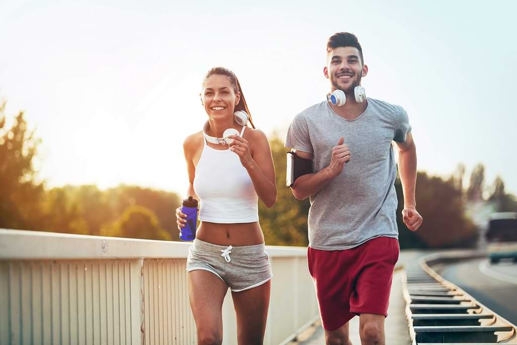 two smiling people running