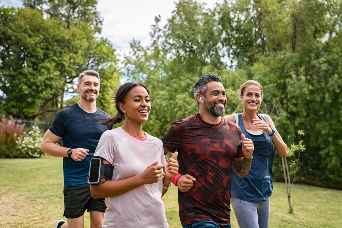 Group of four people running outdoors in a park